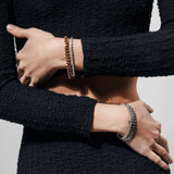 Model wearing a **four-piece bracelet stack** in mixed metals, featuring two gold and two silver bracelets with curb chain and pavé details. ||| SILVER