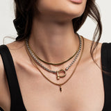 The Herradura and the Snake Layered Necklace Set, which is a 3-piece mixed metal layered necklace set featuring a gold snake chain, a silver and gold Herradura pendant chain, and a gold chain with a lightning bolt charm.