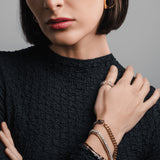 Model wearing the Square Mix Hoops Earrings paired with a three-piece mixed metal bracelet stack and the  Twirl Thumb rings two with crystal accents. ||| GOLD