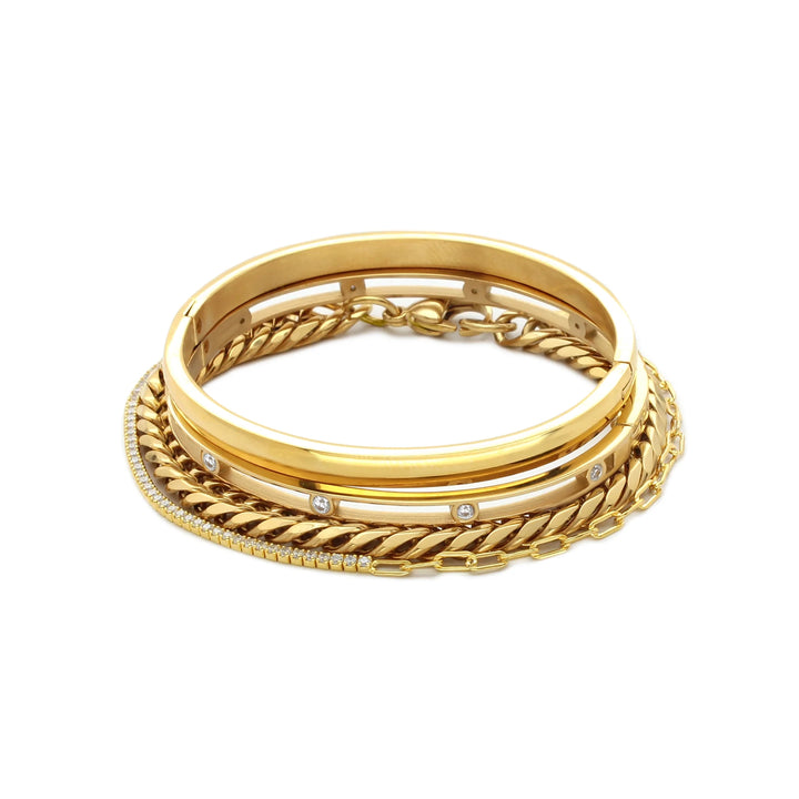The Chain Gold Bracelet Stack, a four-piece set of gold bracelets including a chunky chain bracelet, two bangles (one with cubic zirconia accents), and a delicate chain with cubic zirconia accents.


