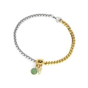 The RISTRETTO BLENDED BRACELET, which is a single two-tone bracelet combining silver and gold chains, features playful charm accents, including a green pavé circle and a gold-tone triangle. This unique piece is perfect for adding a touch of color and personality to any look.