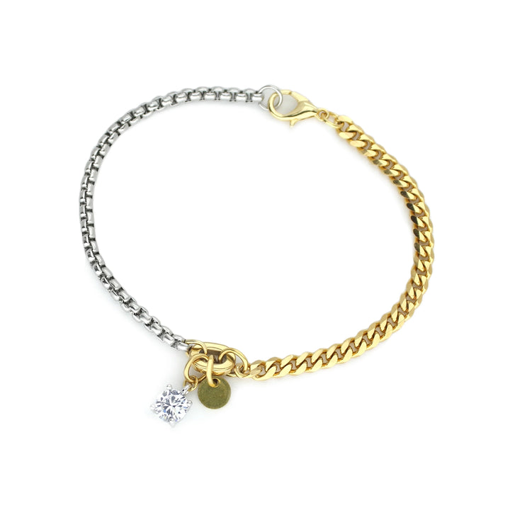 The LUNGO BLENDED BRACELET, which is a two-toned chain bracelet, features a combination of gold and silver links for a versatile, mixed-metal look. The bracelet is adorned with a sparkling crystal charm and a small, gold-tone round pendant, adding a touch of elegance and uniqueness.






