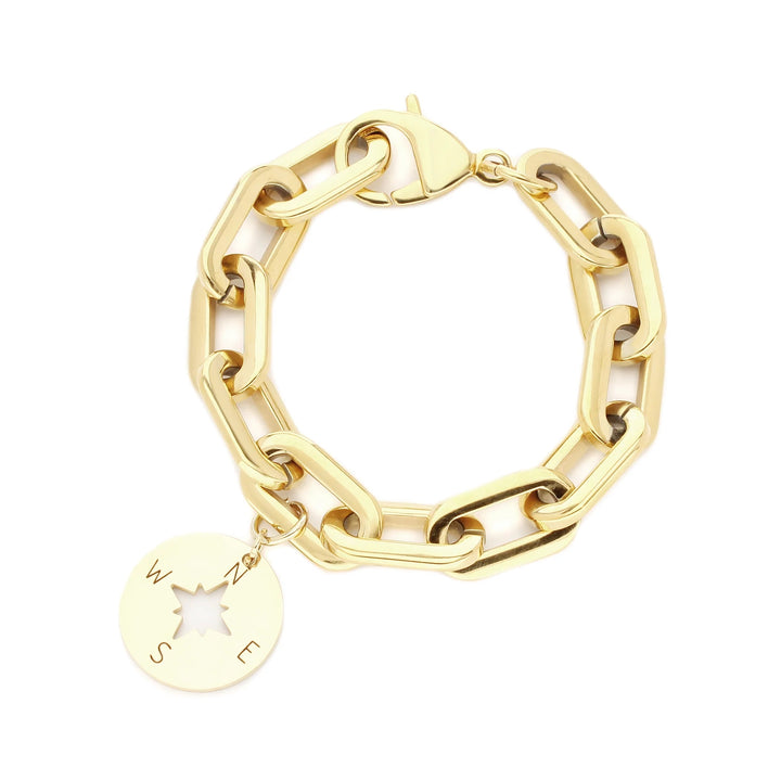 The PUERTO CERVO BRACELET which is a gold chain bracelet with a compass charm.