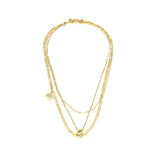 The PURE NECKLACE SET, which is a layered gold-tone necklace featuring three distinct chains, combines delicate and bold designs for a versatile and chic look. This set includes minimalist pendants, including a circular medallion and an elegant oval charm, perfect for adding a touch of sophistication to casual or formal outfits.