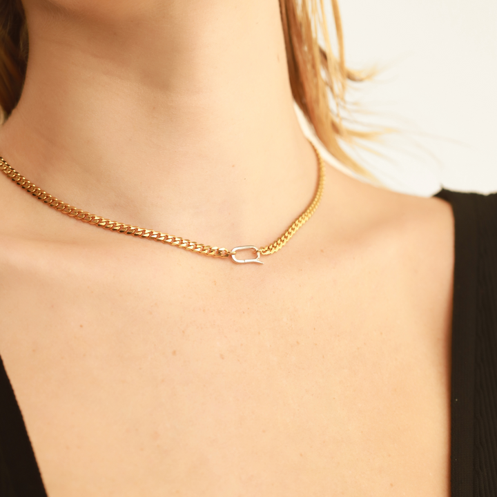 Model wearing the Bold Cuban Chain Necklace featuring a thick, flat gold  link design and a silver can opener secure clasp. ||| SILVER