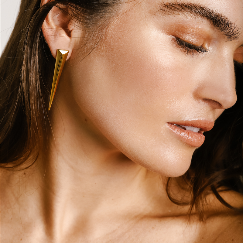 Model wearing the Gold Half Needle earring comes in one piece only which is made of Gold plated spike shaped earring. It is a long triangular earring.