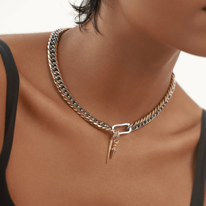 The JUST CLICK SPIKE CHAIN, a single mixed-metal chain necklace with silver links bordered by gold edges, featuring a pave-accented clasp and two dangling spike-shaped charms for an edgy, stylish look.