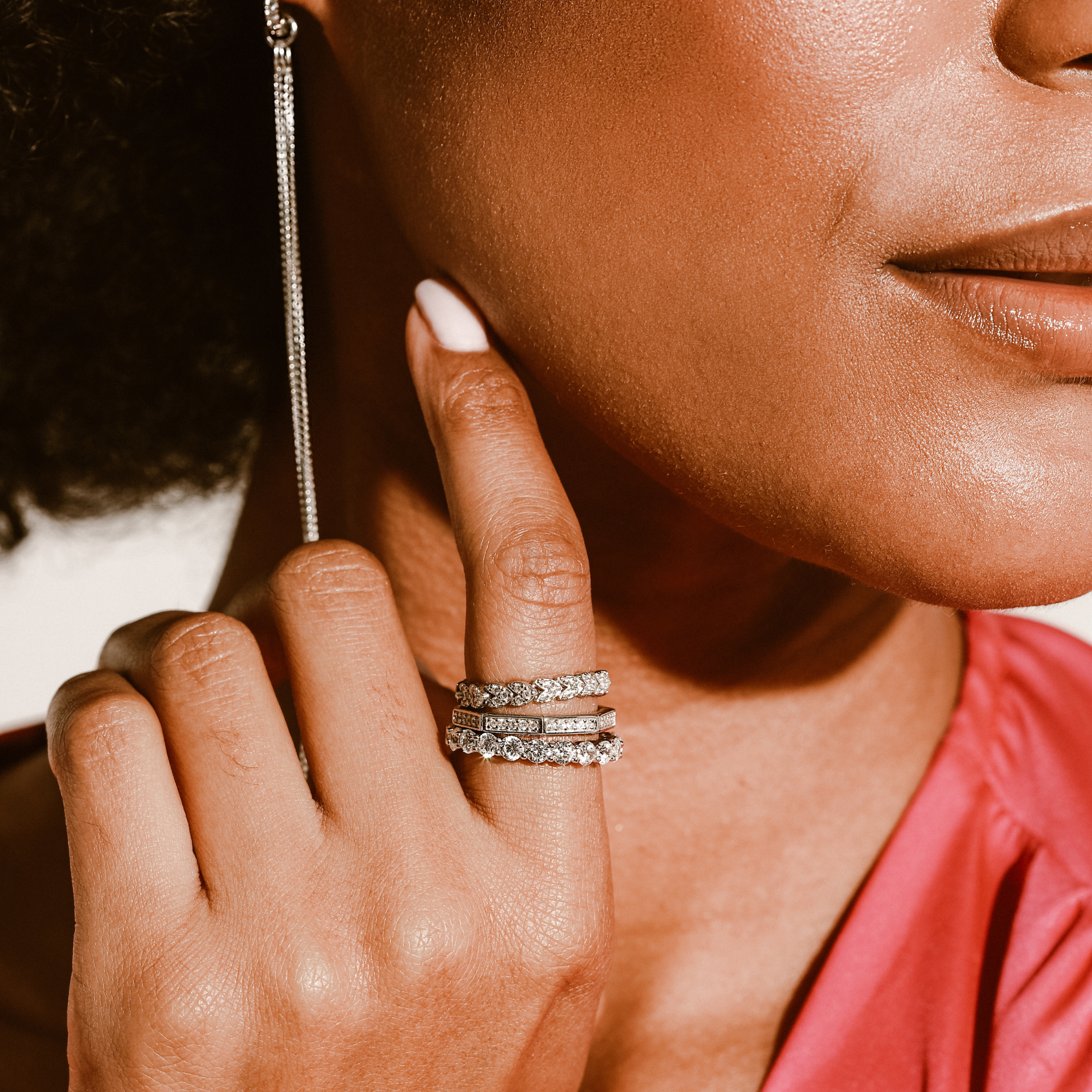 Model wearing the Eternity ring which is 3mm in width made of 925 sterling silver covered with Cubic zirconia. and also two other silver with zirconia rings. She is also wearing the infinity huggies.