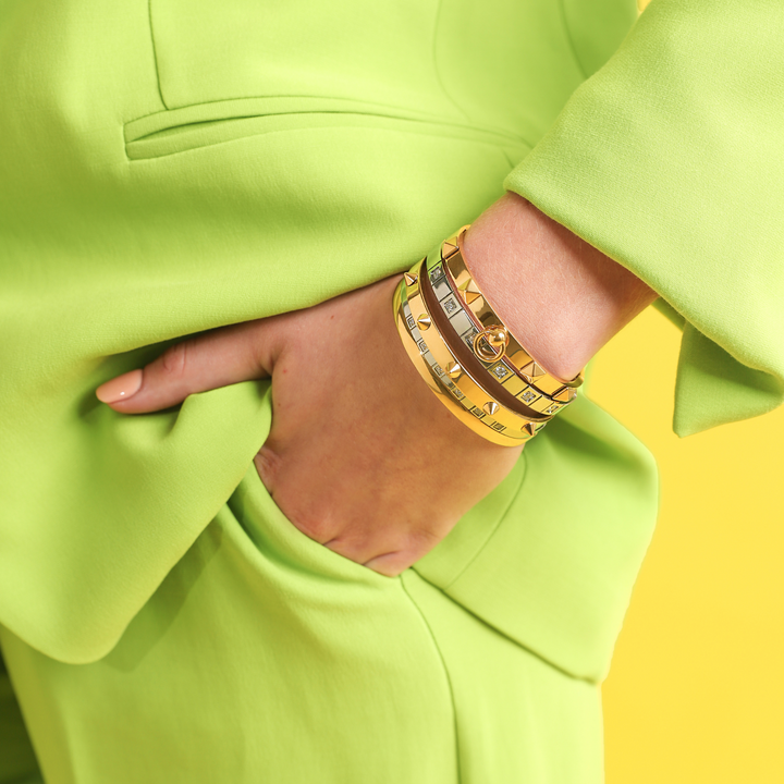 Model wearing the ANIMATED STACK which comes with 5 bangles stack. It includes the plain bangle, spike bangle and square spikes bangle all made of 18k gold plated stainless steel and two silver bangles with Encrusted zirconia.