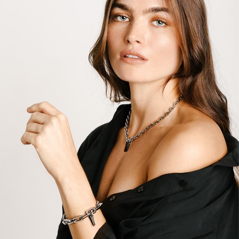 Model wearing the Bamboo Necklace in Silver and the Light Bracelet Silver which is 8 inches in length, Stainless steel link chain with Black Triangle charms & Zirconia.