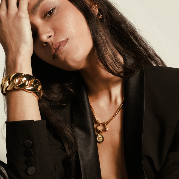 Model wearing the Herradura Zodiac necklace and the BOLD CHAIN CUFF which is made of 18k gold-plated stainless steel. It's 1.2" wide oversized chain design cuff.