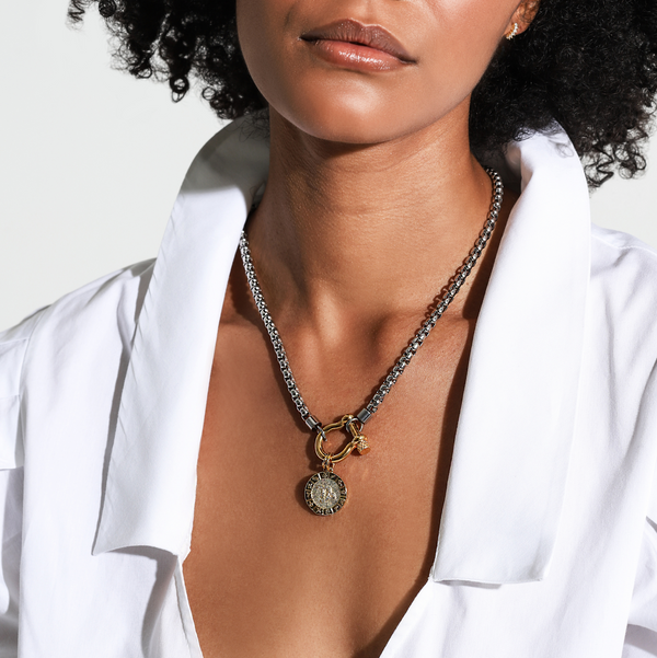 Model wearing the Herradura Zodiac Necklace which is made of 18” Hypoallergenic Rhodium Plated Stainless Steel chain with 18K Gold Plated Horseshoe clasp and miniature star pendant and circular star sign micro pave constellation charm.
