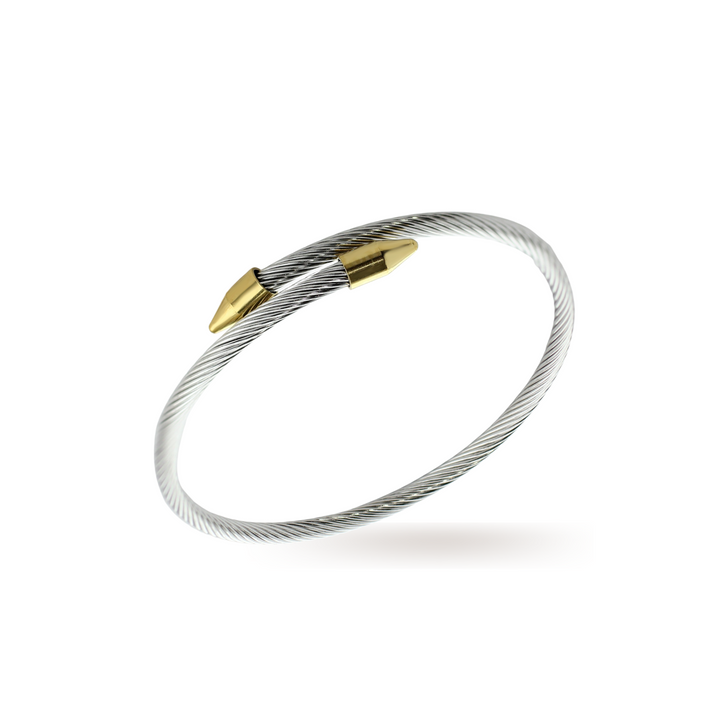The Clavo Wire, which is a sleek and modern silver-tone cable bracelet accented with polished gold-tone nail-head details, designed for a minimalist yet bold statement.