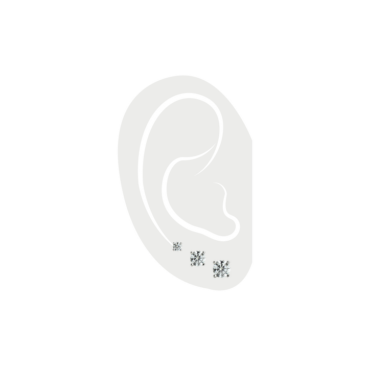 The Triple Solitaire Earring, a set of three silver stud earrings featuring cubic zirconia stones in graduated sizes.