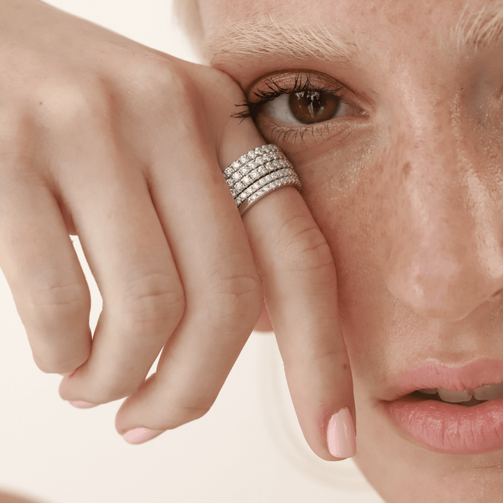 Model wearing stack of The Full Eternity Band Ring, a silver ring featuring a continuous line of sparkling diamond-like stones.