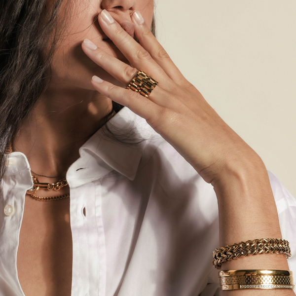 Model wearing layered necklaces, two gold chain rings, marinero bracelet, the DUO stack and the Dust bangle.