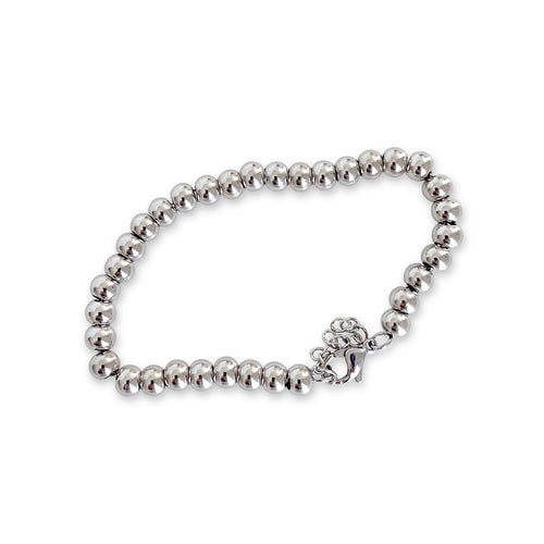 The Puntitos Silver M, which is a single-piece silver bracelet, features a string of polished silver beads with a delicate charm, creating a minimalist yet eye-catching design perfect for adding subtle shine and elegance to any look.