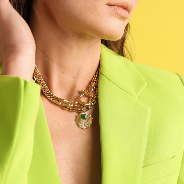 Model wearing The EMERALD HERRADURA which is a 2 layered chain set comes with 18k Gold plated stainless steel chunky chain with gold horseshoe clasp and another thin chain with the Zirconia evil eye charm and a man-made 18k gold plated emerald pendant disc.