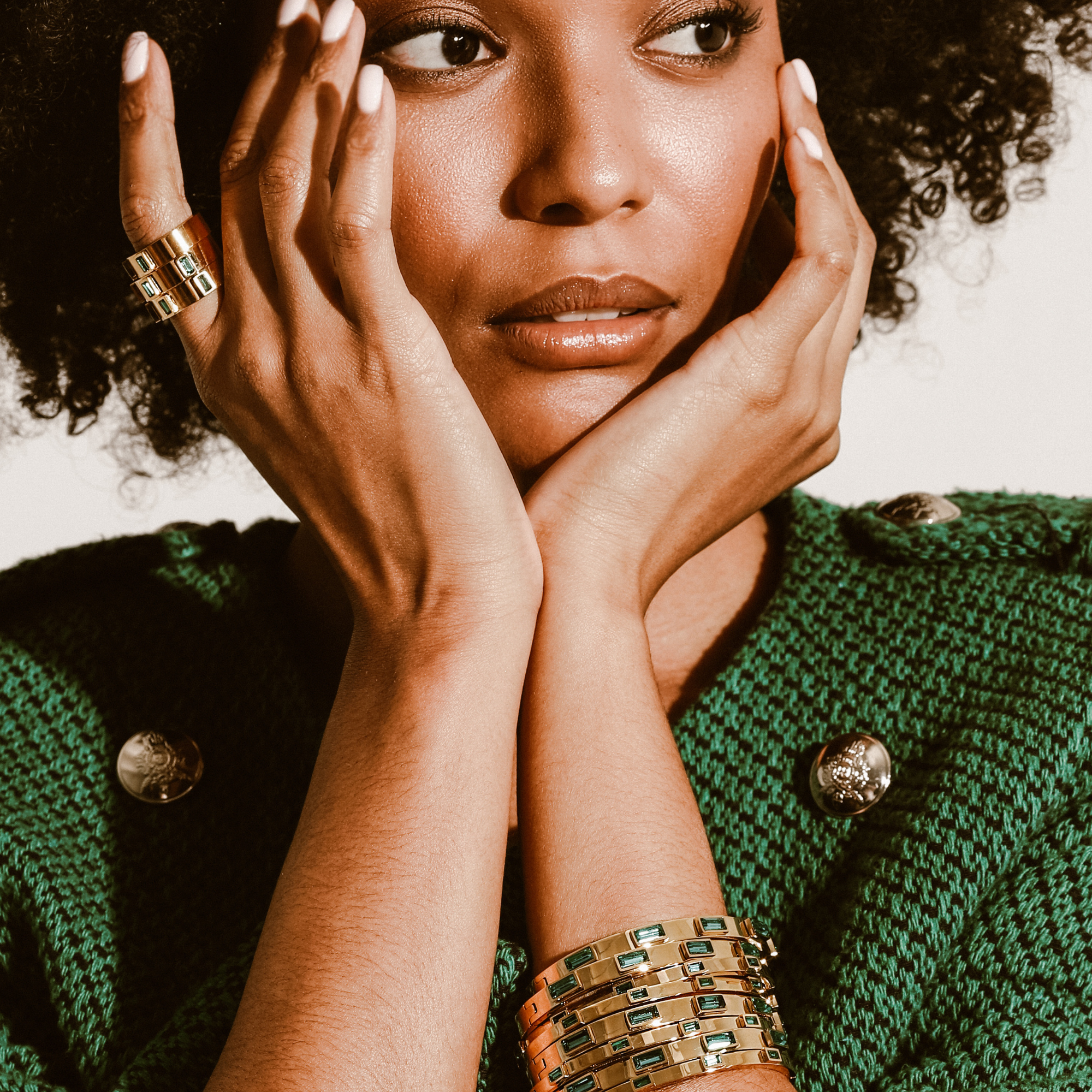 Model wearing three Emerald rings and stack of Emerald skinny bangles that are 3mm width 18k gold plated stainless steel with 5 emerald zirconia stones encrusted and the Emerald bangle which are 5mm in width.