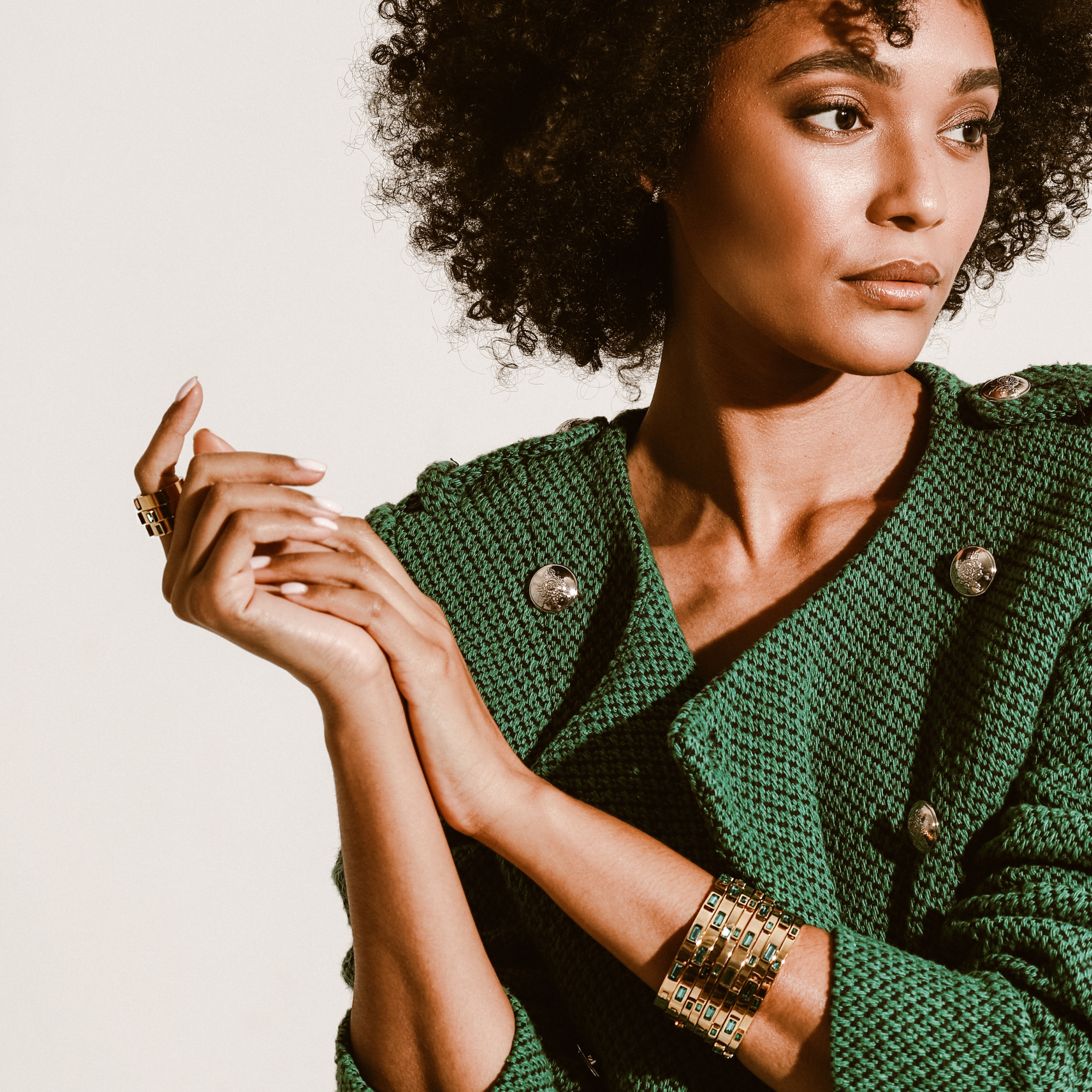 Model wearing three Emerald rings and stack of Emerald skinny bangles that are 3mm width 18k gold plated stainless steel with 5 emerald zirconia stones encrusted and the Emerald bangle which are 5mm in width.