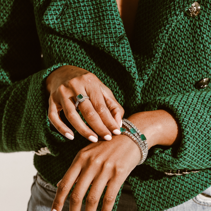 Model wearing three EMERALD CUT TENNIS BRACELET which is made of 925 sterling silver, high carbon diamond and a man-made emerald stone. She is also wearing the Em cut ring.