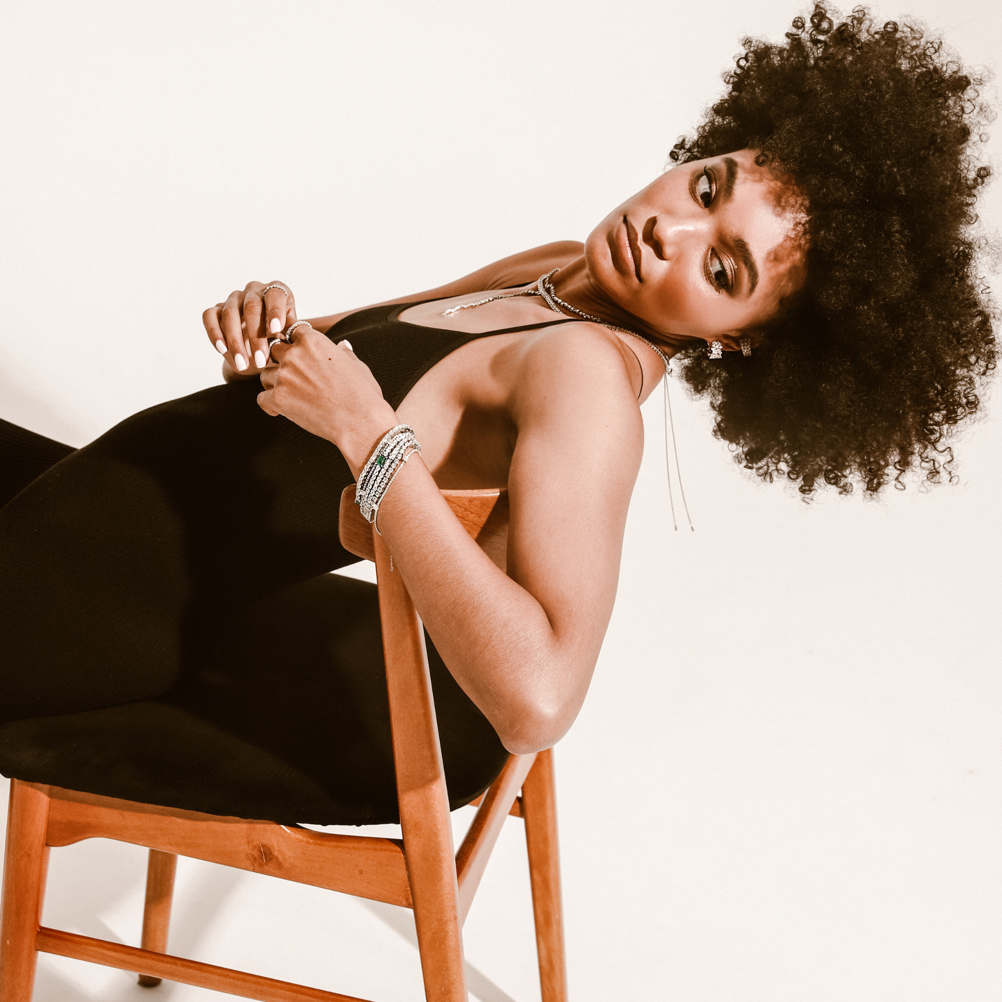 Model wearing the ETERNITY EAR CUFF which is 10mm in width and comes in copper and covered with Cubic zirconia. She is also wearing a stack of silver chain bracelets and the Em bracelet.