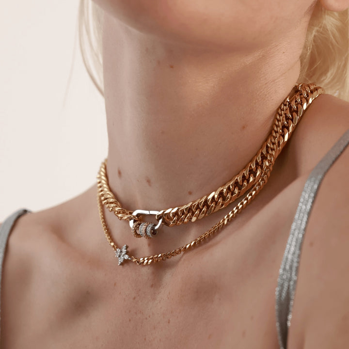 The JUST CLICK HOOPS CHAIN, a layered gold chain necklace featuring a silver click clasp with donut-shaped sparkling accents, styled with an additional delicate gold chain with a small silver star pendant for a chic, mixed-metal layered look. ||| GOLD