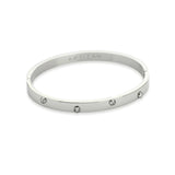 The ON BANGLE, which is a single, elegant silver bracelet, features a polished finish with evenly spaced crystal accents for a touch of sparkle. This minimalist piece is perfect for standalone wear or stacking with other bracelets to elevate any outfit.