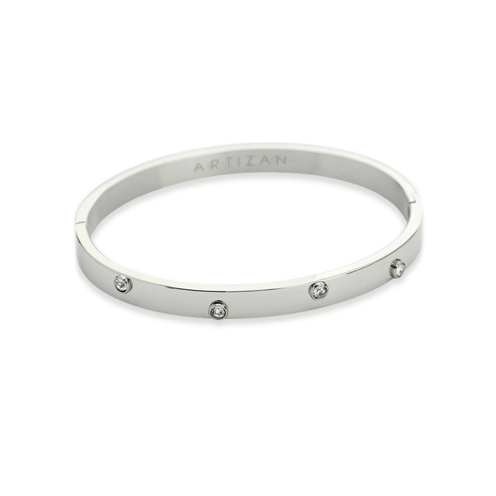 The ON BANGLE, which is a single, elegant silver bracelet, features a polished finish with evenly spaced crystal accents for a touch of sparkle. This minimalist piece is perfect for standalone wear or stacking with other bracelets to elevate any outfit.