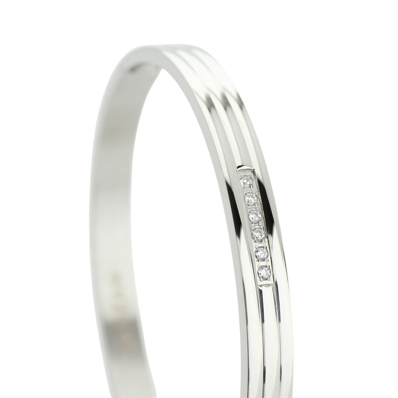 The MIDDLE LANE BANGLE which is made of rhodium plated Stainless steel with six tiny Cubic zirconia and dimensions of 2.8" x 1.77".