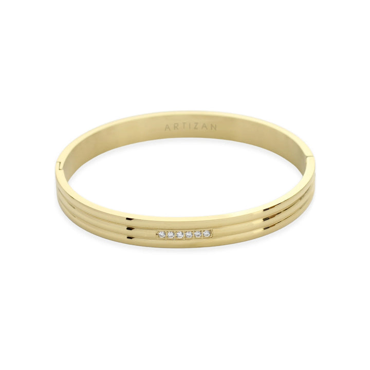 The Lane Bangle, a polished gold bangle featuring a sleek, minimalist design with a subtle row of sparkling stones on the front. This elegant bracelet can be worn solo or stacked with other bangles for a refined, sophisticated look, perfect for both casual and formal occasions.