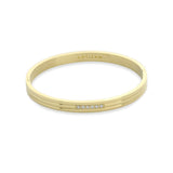 The MIDDLE LANE BANGLE, which is a single sleek gold bracelet, features a modern design with a delicate row of five sparkling cubic zirconia stones embedded at the center. This minimalistic yet elegant bangle is perfect for adding a touch of sophistication to everyday wear or special occasions.