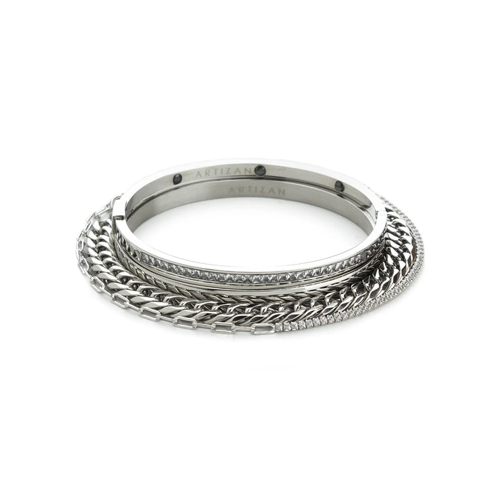 The Chain Silver Bracelet Stack, a four-piece set of silver bracelets featuring a chunky chain bracelet, two bangles (one with cubic zirconia accents), and a delicate chain with cubic zirconia accents.







