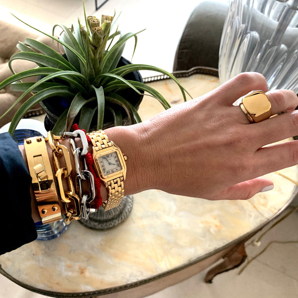 Model wearing the Forever Ring in Gold. She is wearing a gold watch, two Puerto Chain bracelets in gold and silver and the Belt Cuff Medium in Gold.