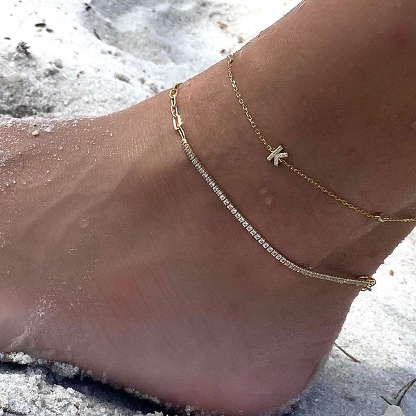 Model wearing the Letter ANKLET SET which comes with TWO 925 sterling silver, gold plated anklet. One with plain chain and the other comes with a  Zirconia letter charm and zirconia stones.