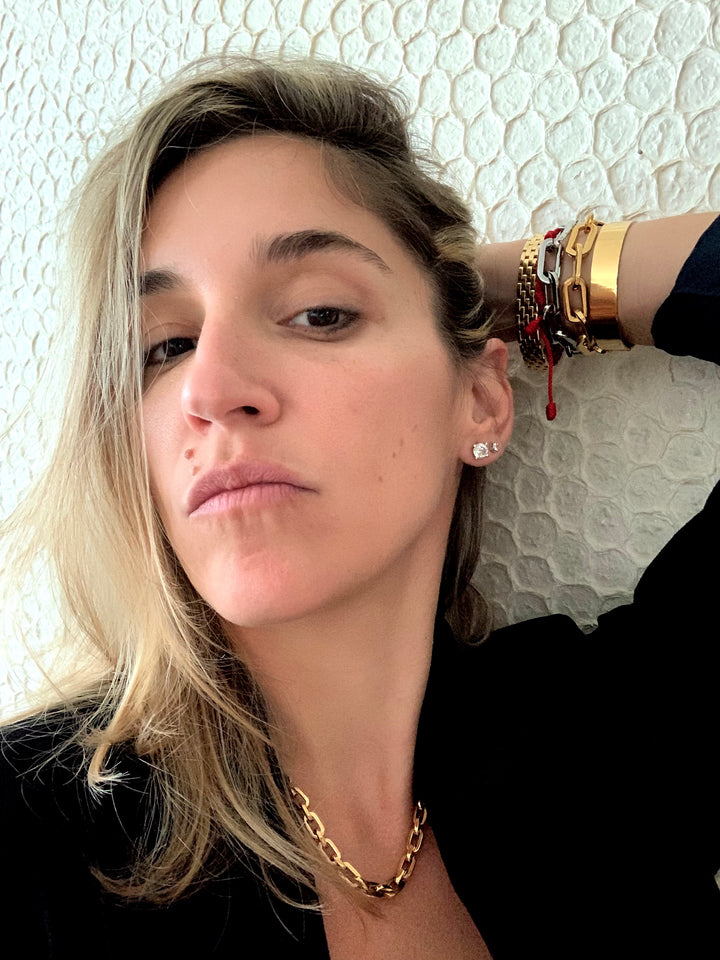 Model wearing the Puerto Chain Small which is made of Stainless steel 18k gold plated chain links. The necklace is 16 inches long and great for layering necklaces.. She's also wearing the Belt Cuff Medium Gold, Puerto chain bracelet in Gold and Silver and a gold watch.
