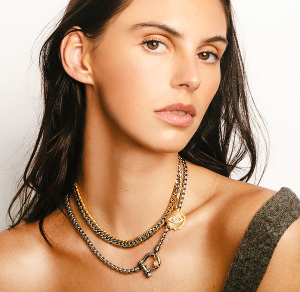 Model wearing the Herradura Eye necklace set which comes with the Silver Herradura chain with Gold Eye Zircon Pendant and the Mix Chain thin necklace with a Micro Pave sun pendant.