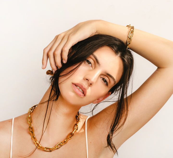 Model wearing the Puerto Gold seet which comes with a Puerto Chain necklace and bracelet in Gold plated stainless steel. ||| GOLD