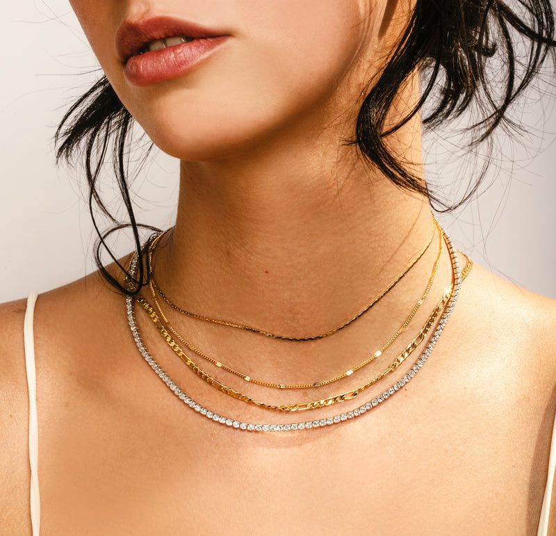 Model wearing the I DO NECKLACE SET which comes with two 18k Gold plated Stainless steel chains and a Tennis necklace and another short thin gold necklace.