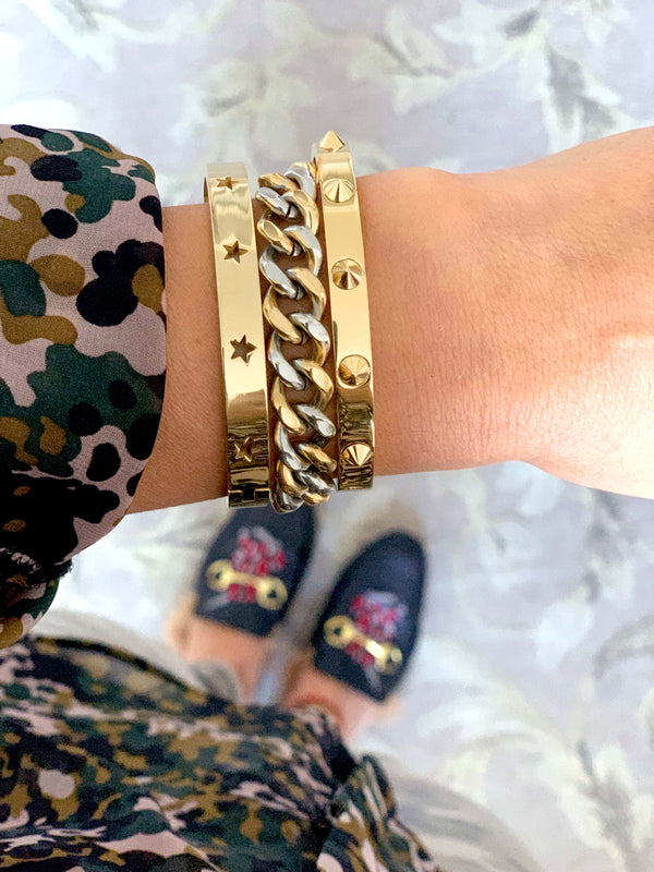 Model wearing the the Sila Stack which comes with three bracelets. One is the gold spike bangle, mix chain bracelet and the shooting stars bangle in gold.