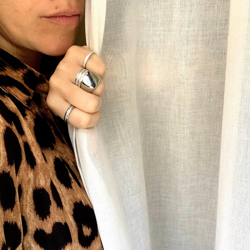 Model wearing a leopard print top accessorised with the FOREVER RING SILVER and the Just rings in silver.