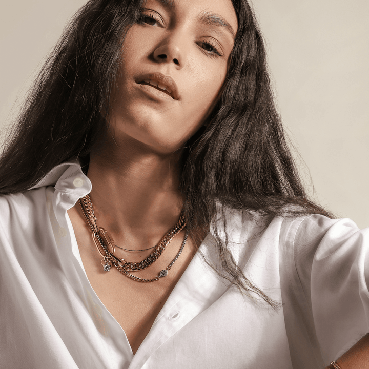 Model wearing the Maya Necklace, 18k Gold plated Stainless steel chain 3  Layered chain set with one thin gold chain, half gold and half silver chain with Zirconia evil eye and a thicker gold chain with oval lock.