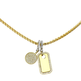 A gold necklace chain with the plaque charm and t he Circle Clip-On Charm, which is a two-toned charm featuring a circular gold pendant paved with sparkling diamonds and a silver clip embellished with a row of smaller diamonds.