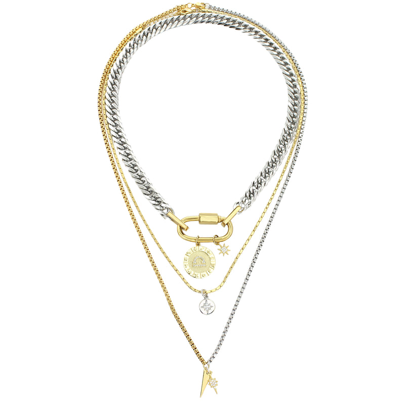 The Anne Zodiac Necklace which is a three pieces layered necklace set. Includes one silver chain with 18k gold plated carabiner and Gold Filled Libra Zodiac with Micro Pave Constellation charm, thin gold necklace with silver circle charm and another long necklace in half gold and silver with spike shaped charm and Gold Plated Micro Pave Studded Star.