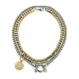 The Herradura Eye Layered Necklace, a bold two-tone necklace featuring dual silver and gold chains with an eye-catching evil eye charm and a sunburst pendant. This statement piece combines chunky layered chains with mystical-inspired charms, perfect for adding an edgy and unique look to any outfit.