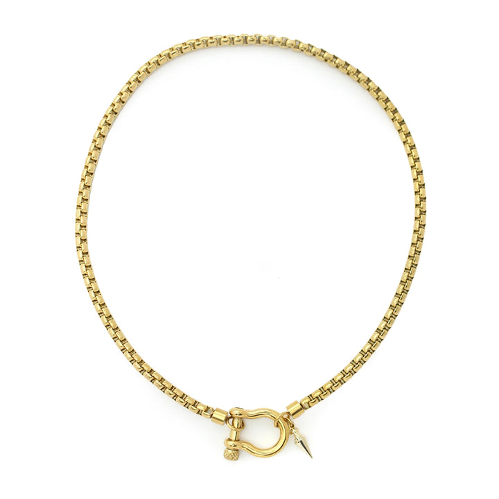The Herradura Spike Necklace, a gold necklace with a spike charm and a unique horseshoe clasp.
