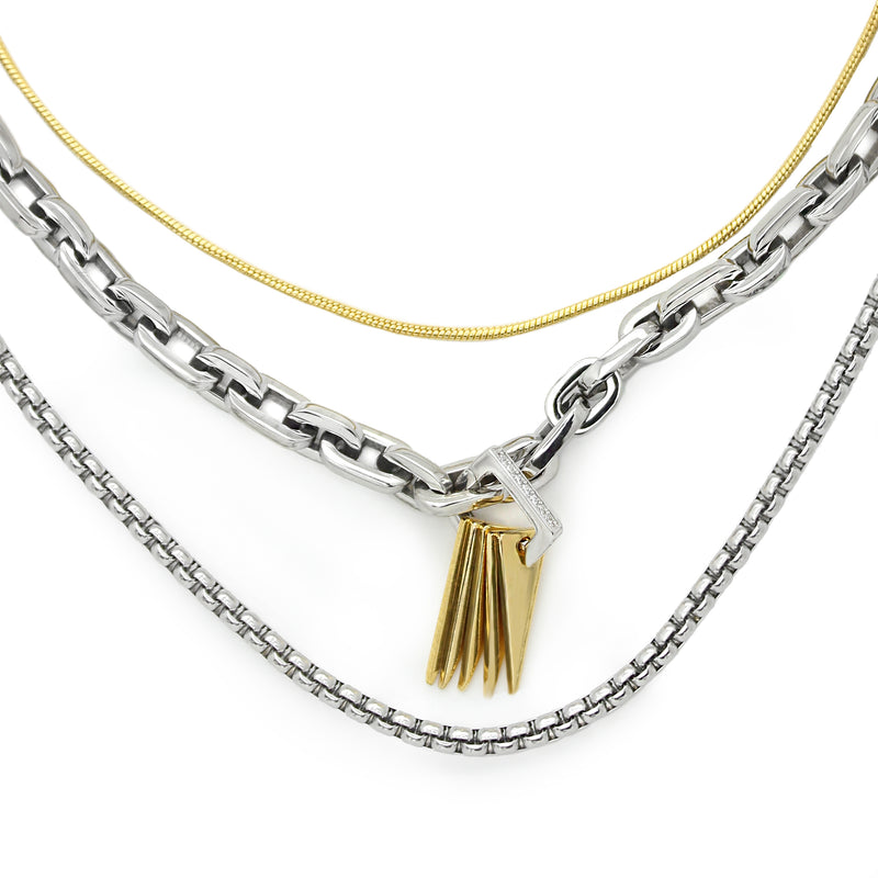 SILENCE LAYERED NECKLACE SET which comes in 3 separate chains. It includes a stainless steel puerto chain which is 17 inches in length with gold triangle charms & Zirconia, one thin gold plated necklace and another thin silver necklace that are 16 and 20 inches in length.