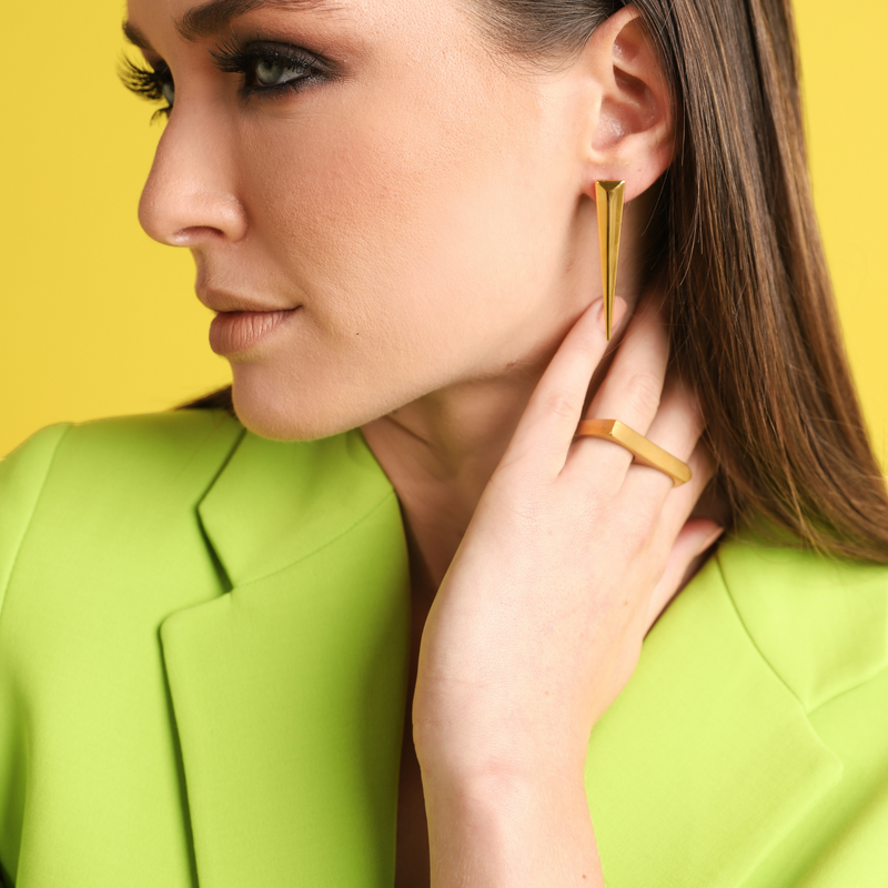 Model wearing The FERVENT RING which is a double ring made of 18k gold plated stainless steel. She is also wearing the needle earring in gold.