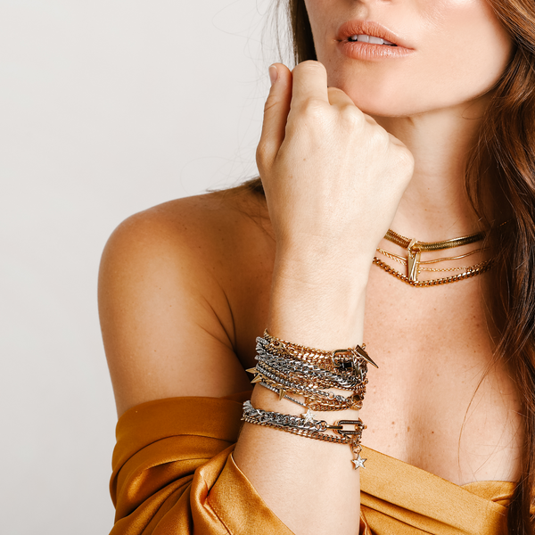 Model wearing the WILD LAYERED NECKLACE SET which includes 4 gold separate chains and stack of bracelet chains which include the Crema Blended Bracelet, La Rosa bracelet, Iron bracelet, Ischia Bracelet in silver and gold, Espresso Blended, Ristretto and the Orzo Blended Bracelet.