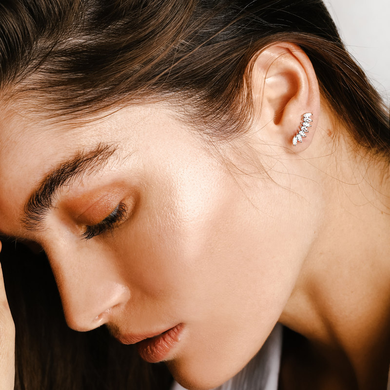 Model is wearing the Positano Earring which is made of a 925 sterling silver and Cubic zirconia. The climber earring is made of 7 leaf-shaped cubic zirconia stones.